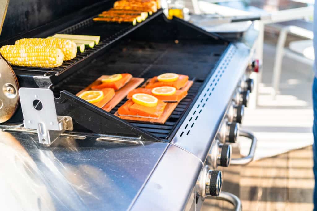Planked salmon being cooked on a natural gas grill