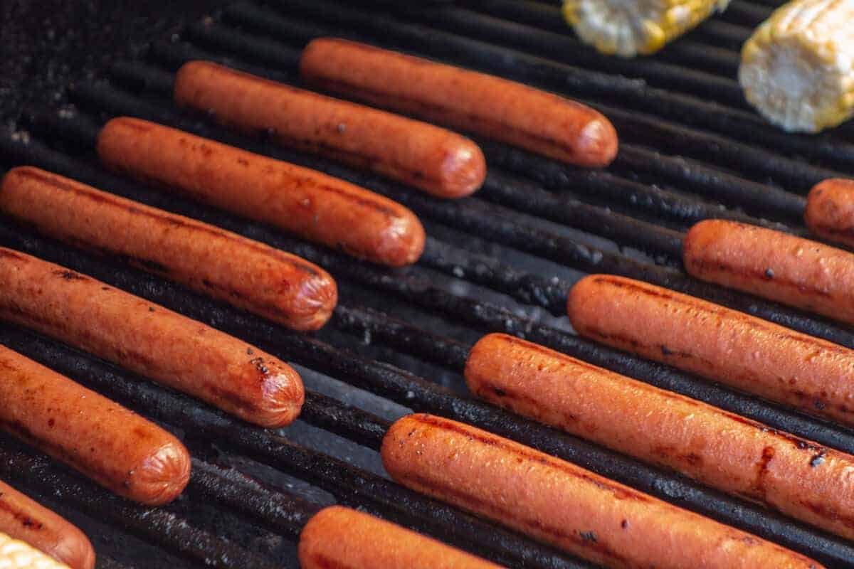 beef hot dogs lined up in a smo.