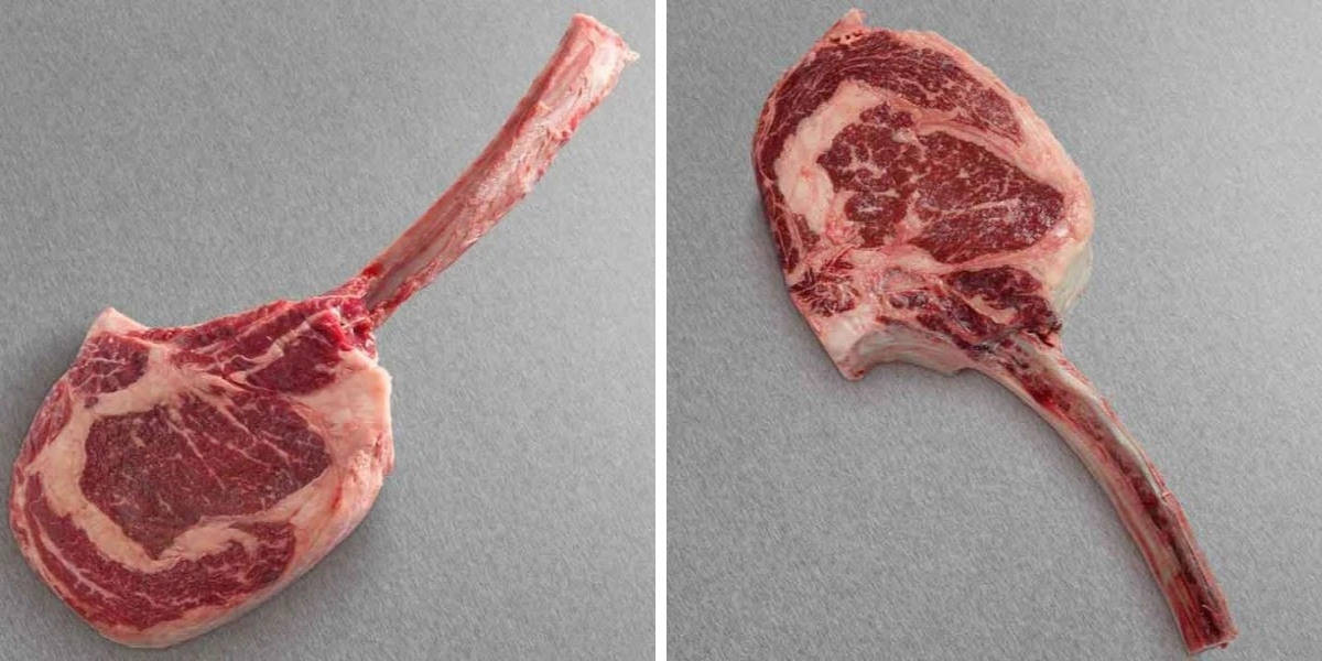 Two tomahawk steaks from Snake River Farms, side by side, on a dark gray backgro.