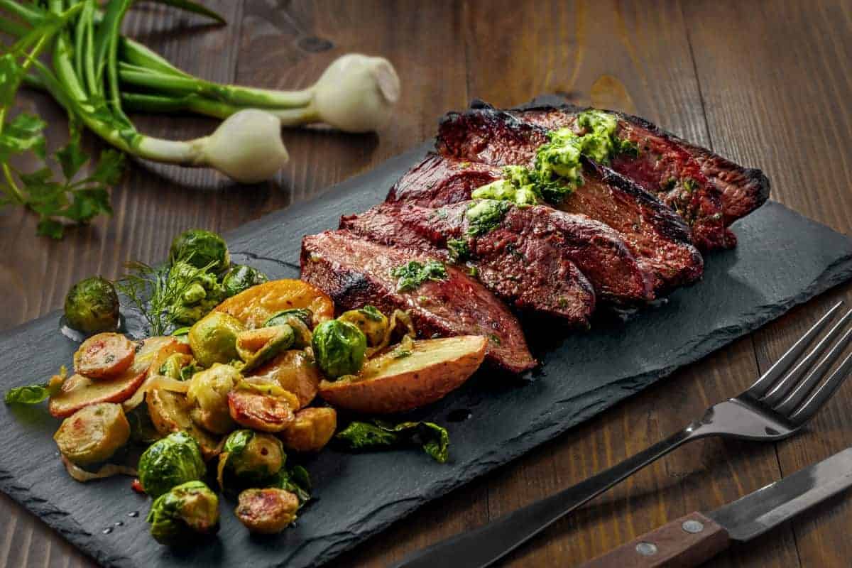 grilled and sliced hanger steak with chimichurri and Brussels spro.