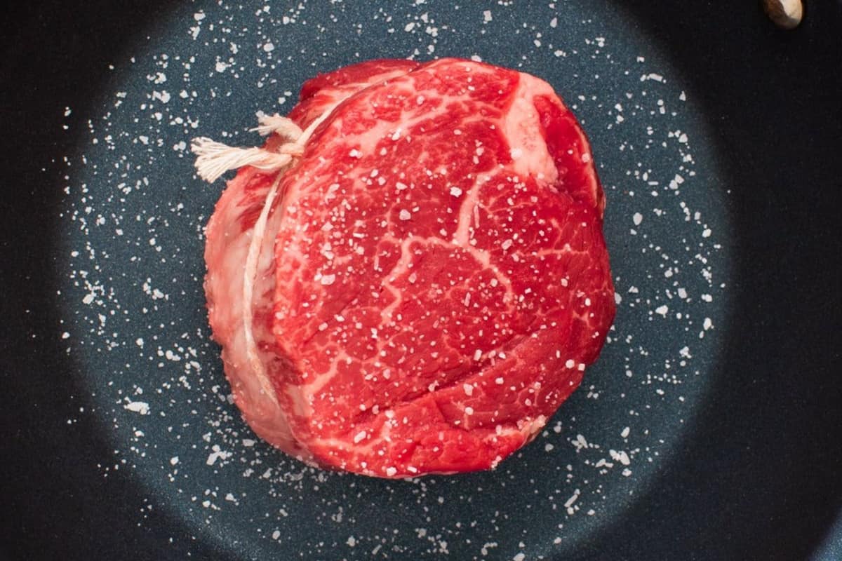 A filet mignon from Porter Road, in a heavy pan and sprinkled with salt