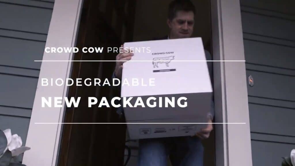 Man holding a box from crowd cow, with text overwrite stating it's bio-degrabable