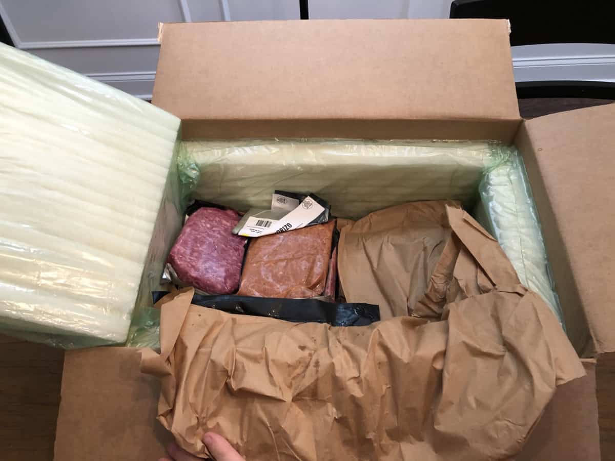 Porter road delivery box opened, with ice packs and brown paper removed, shoing the individually vacuum packed cuts of meat inside
