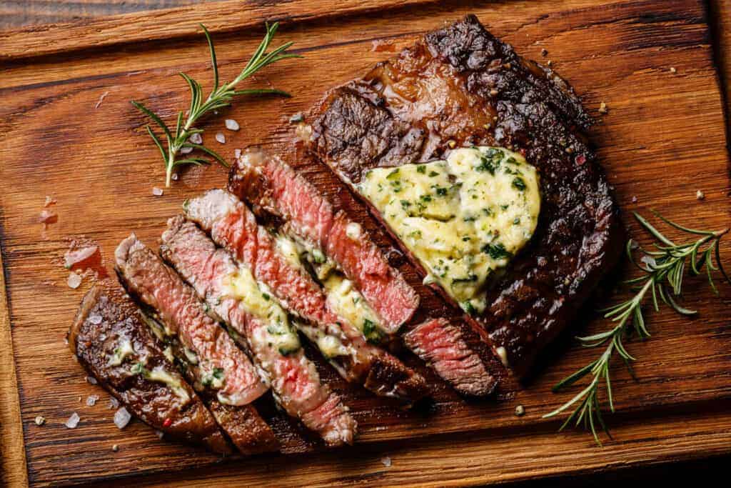 A grilled ribeye steak with melting herb butter on .