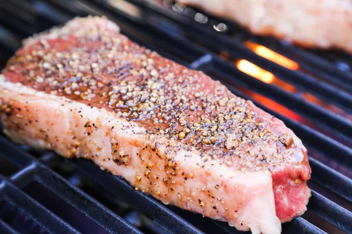 A thick, pepper rubbed sirloin steak on a gr.