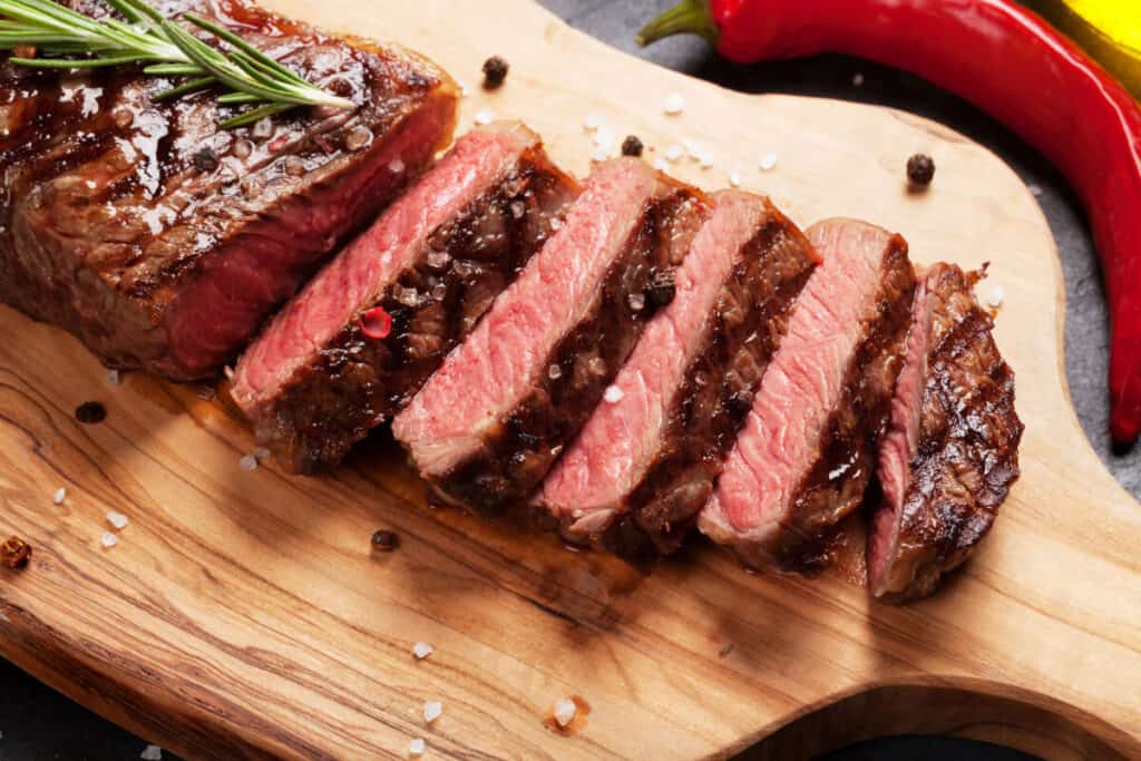 Grilled and sliced medium rare sirloin on a chopping board