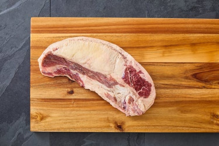 A brisket point from Crowd Cow, laying on a wooden cutting board.