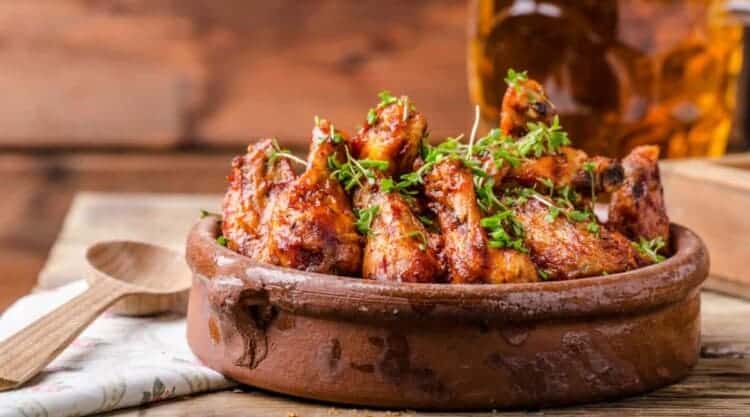 A bowl full of chicken wings with crispy skin.
