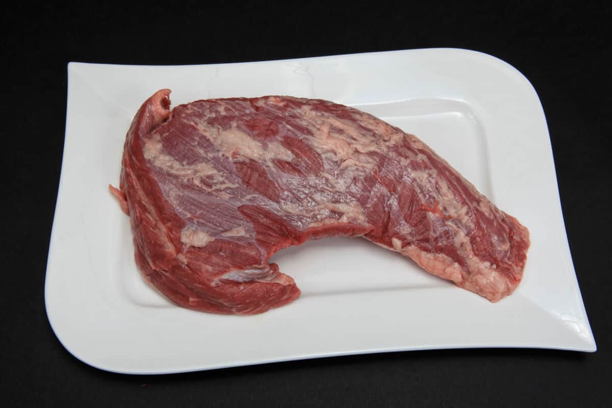 Raw tri-tip on a white square shaped b.