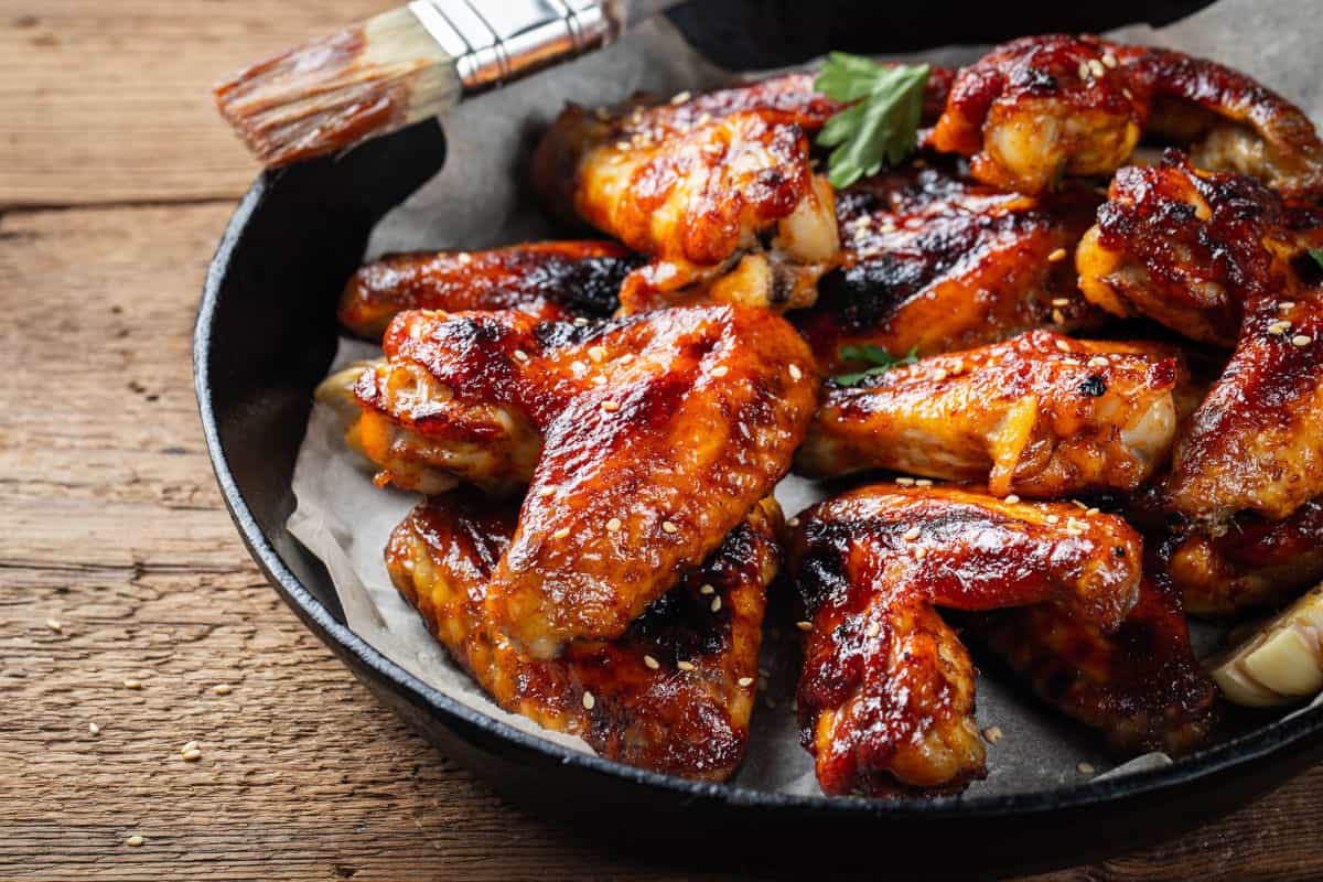 Chicken wings in a frying pan, on parchment pa.