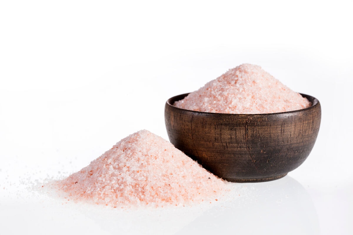 A pile of pink Andean sea salt, next to a bowl of the s.