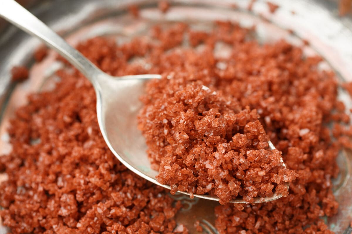 A bowl and spoon full of Hawaiian red salt