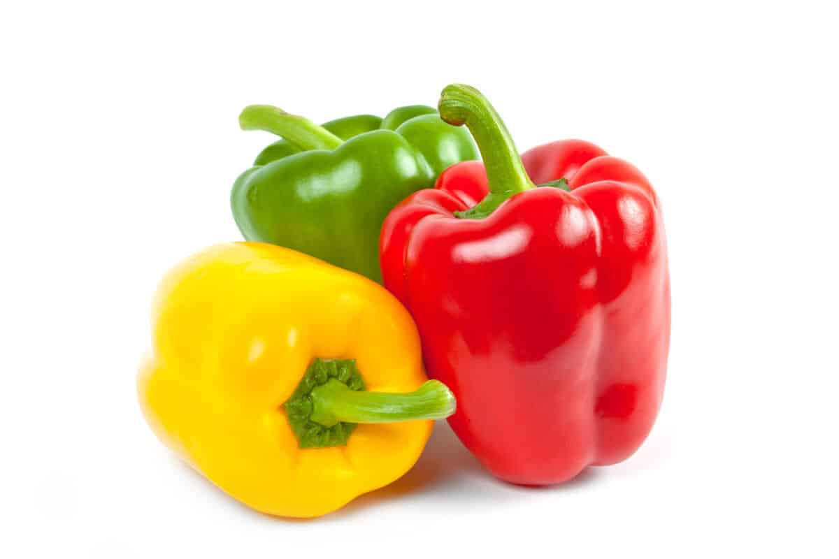 One each of red, yellow and green bell peppers isolated on wh.