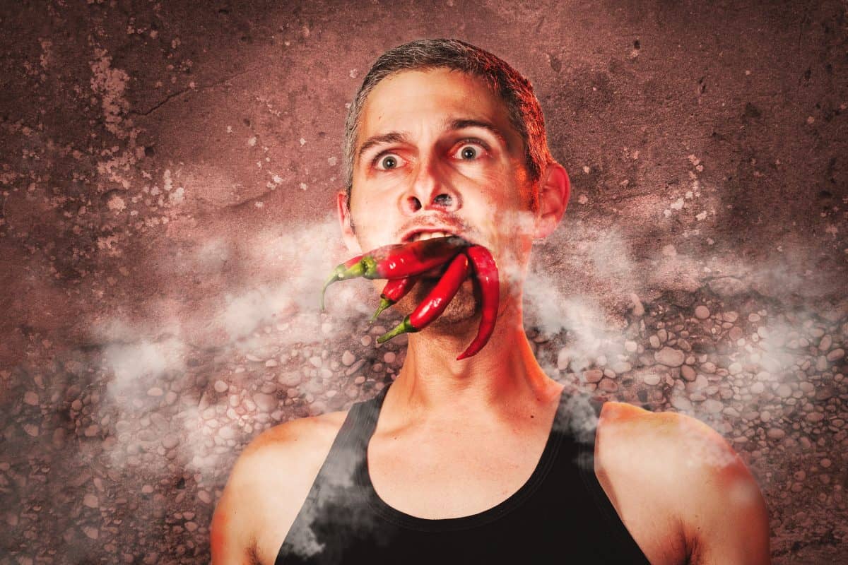 Mock up photo of man with chilies in mouth, and steam coming out of his hot looking f.