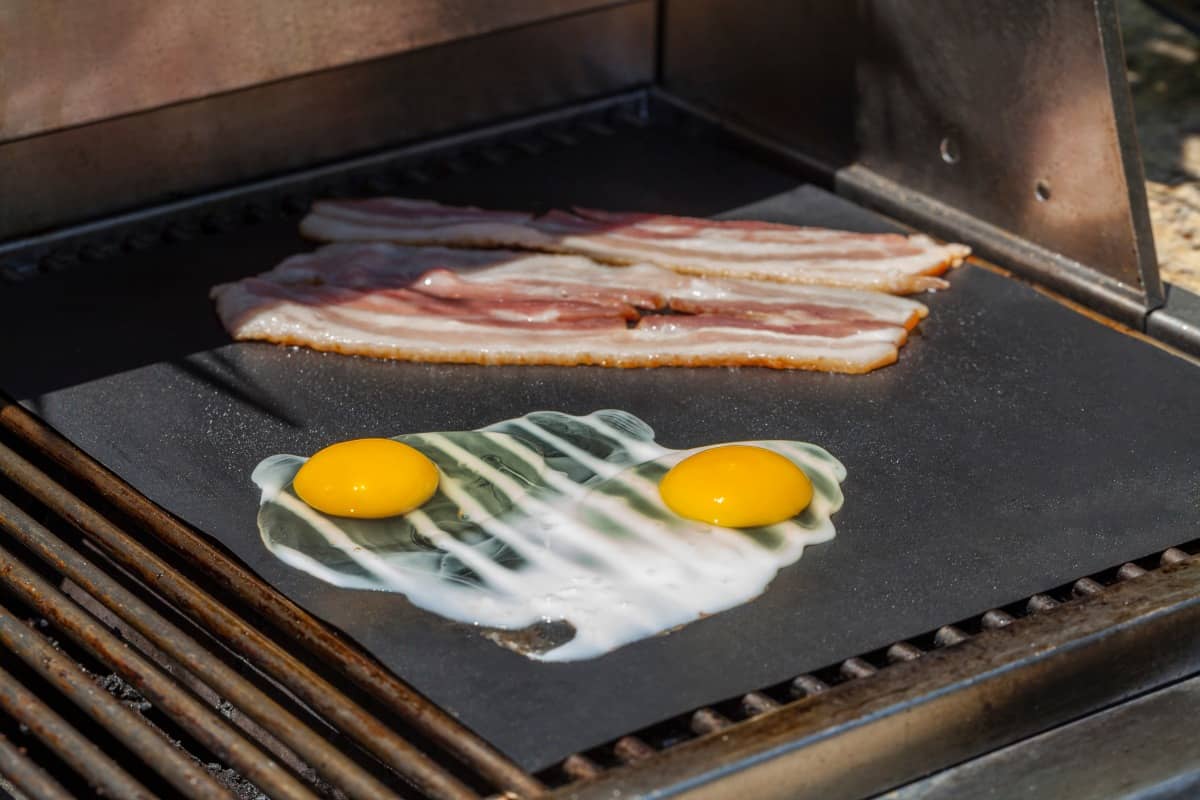 eggs and bacon on grill .