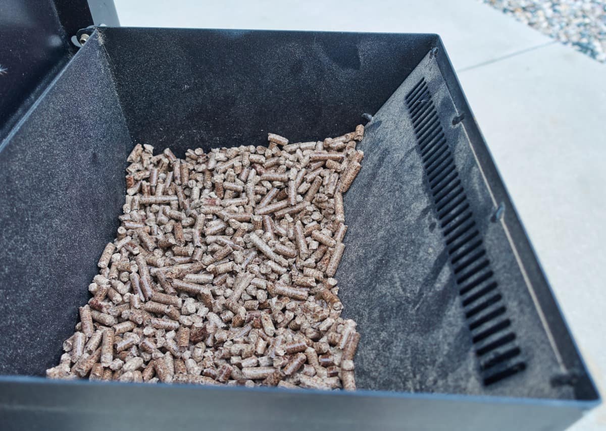 A pellet grill hopper half full of pell.