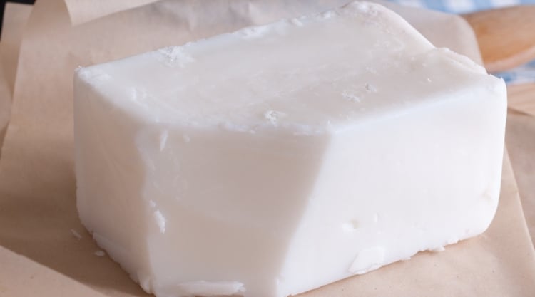 A block of beef tallow on some pink butcher paper.