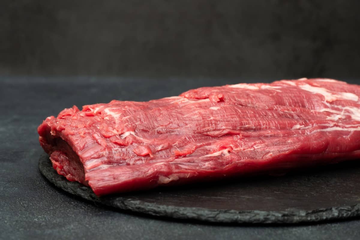 A whole tenderloin on a slate surf.