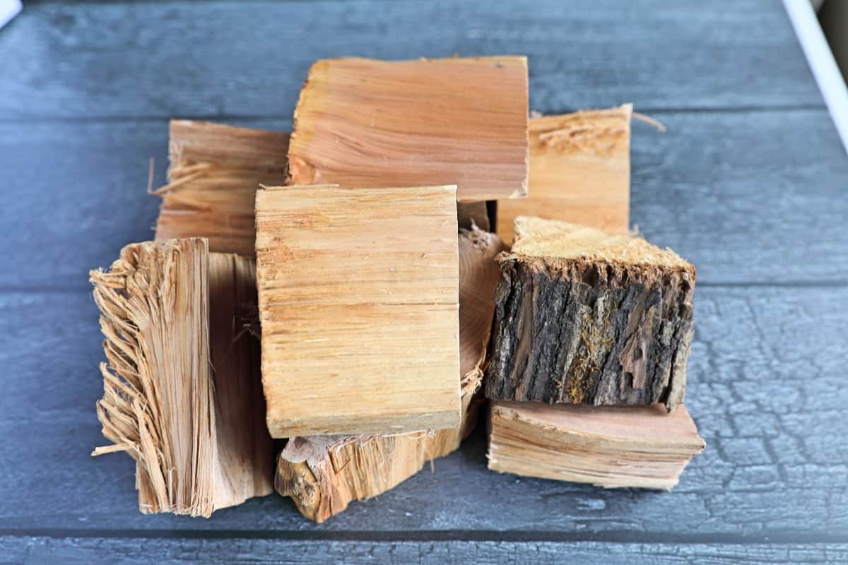 Pile of hickory chunks on a charred wood-looking background.