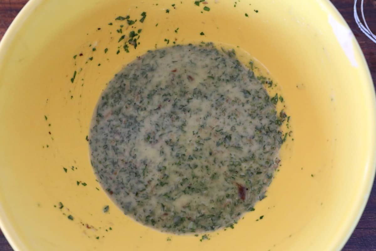 Thoroughly mixed wild garlic and bone marrow butter ingredients in a yellow b.