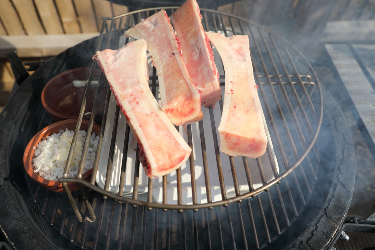 Bone marrow halves, shallots and garlic on the smo.