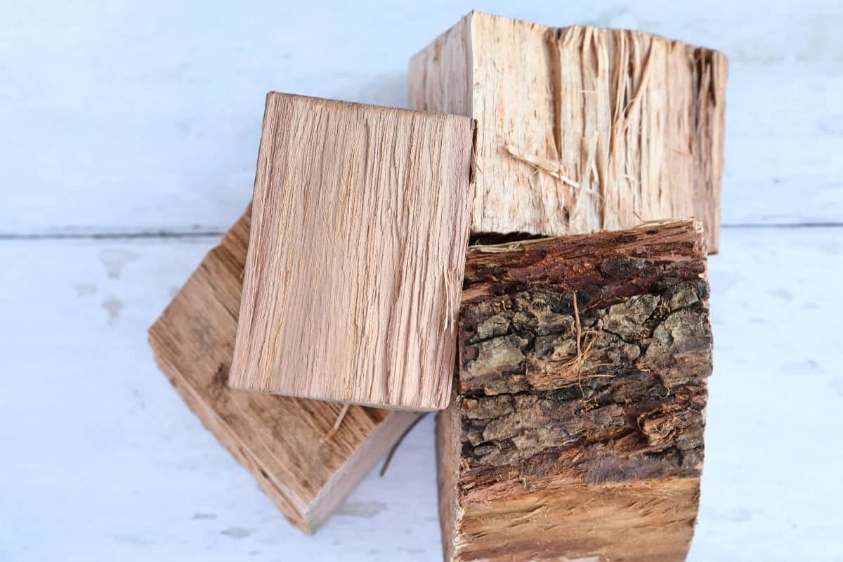 Four pecan wood chunks on a white wooden table