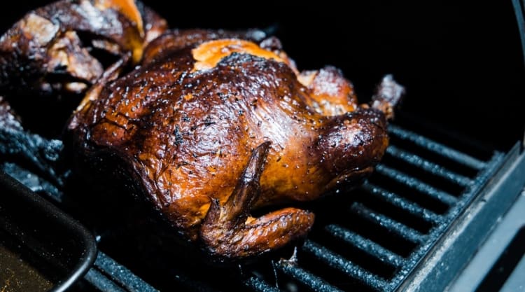 Two chickens in a BBQ smoker, with rubbed and brown crispy skin.