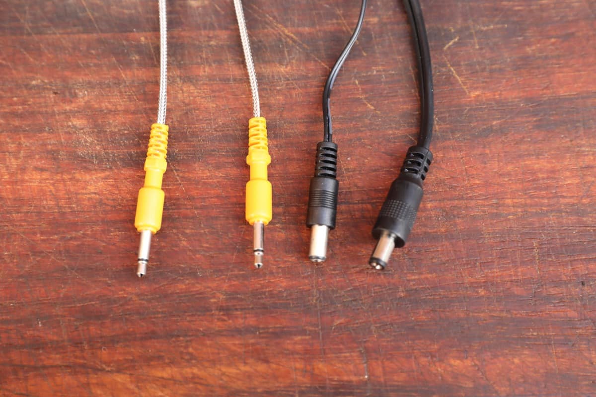 The plugs on the temperature probes, fan and power cable, on a wooden cutting board.