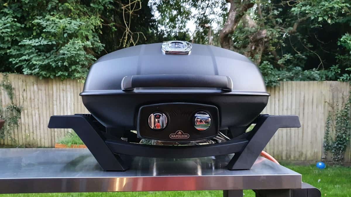 Napoleon 285 pro portable gas grill on a stainless steel ta.