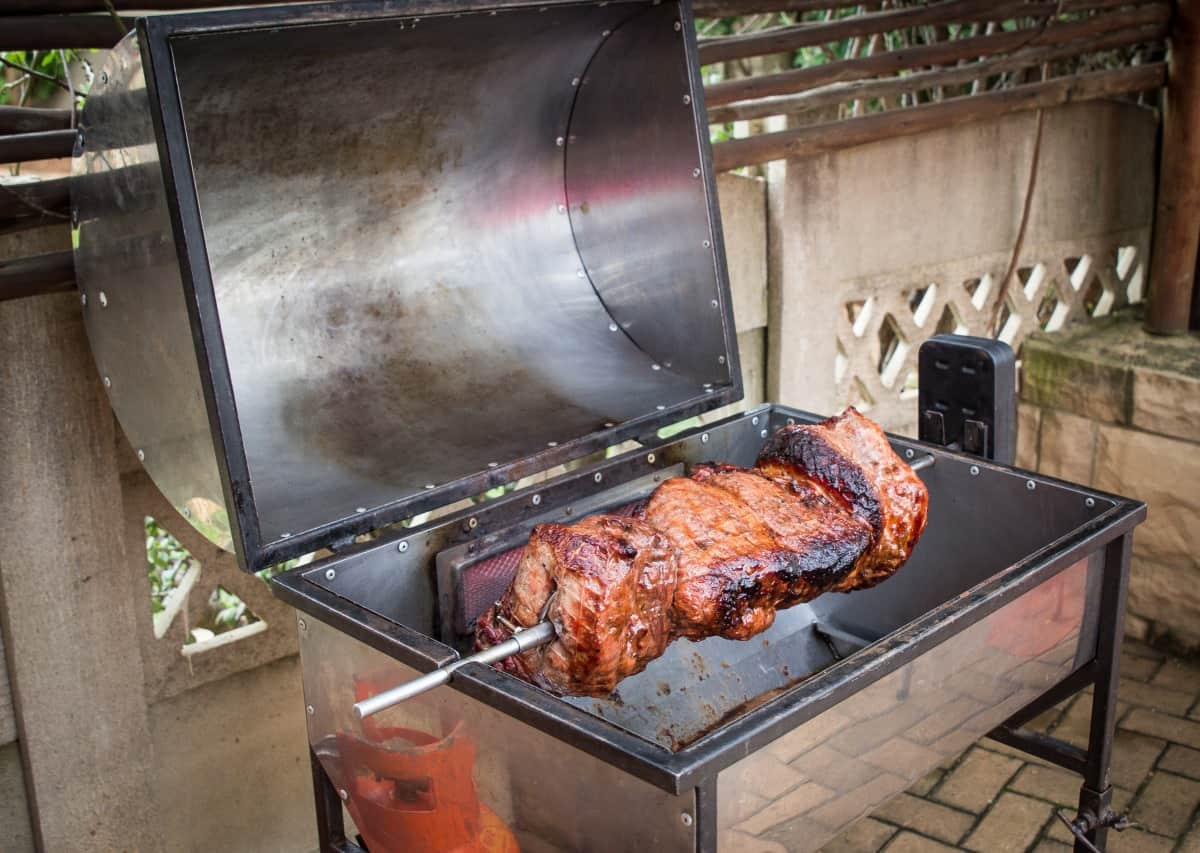 A barrel shaped rotisserie BBQ.