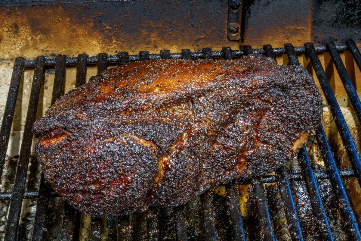 smoked pork butt on the grates inside a smo.