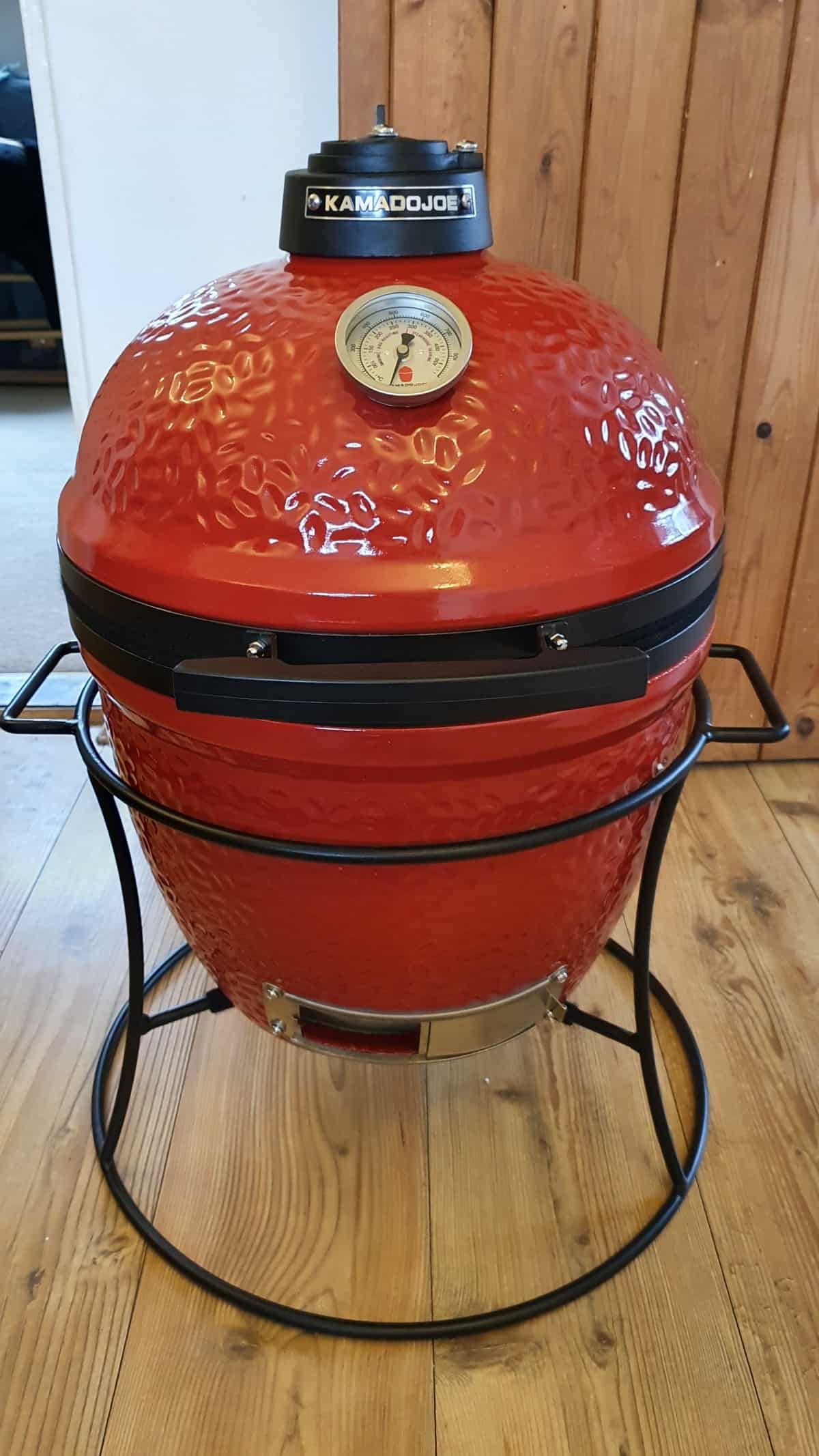 A fully assembled Joe Jr grill sitting on a wooden fl.