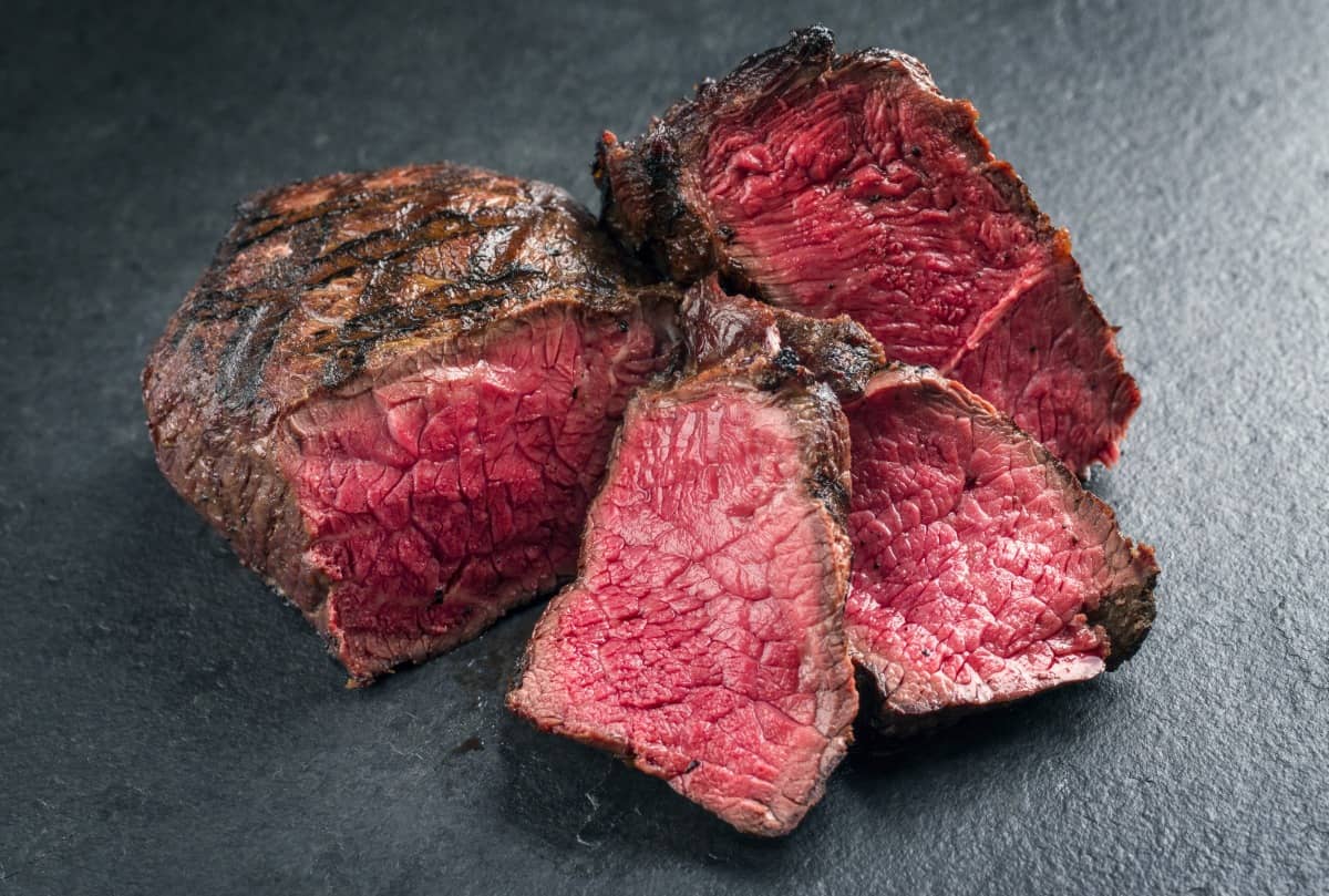 Point steak cooked to rare, sliced, and with crisscross grill marks on the surface