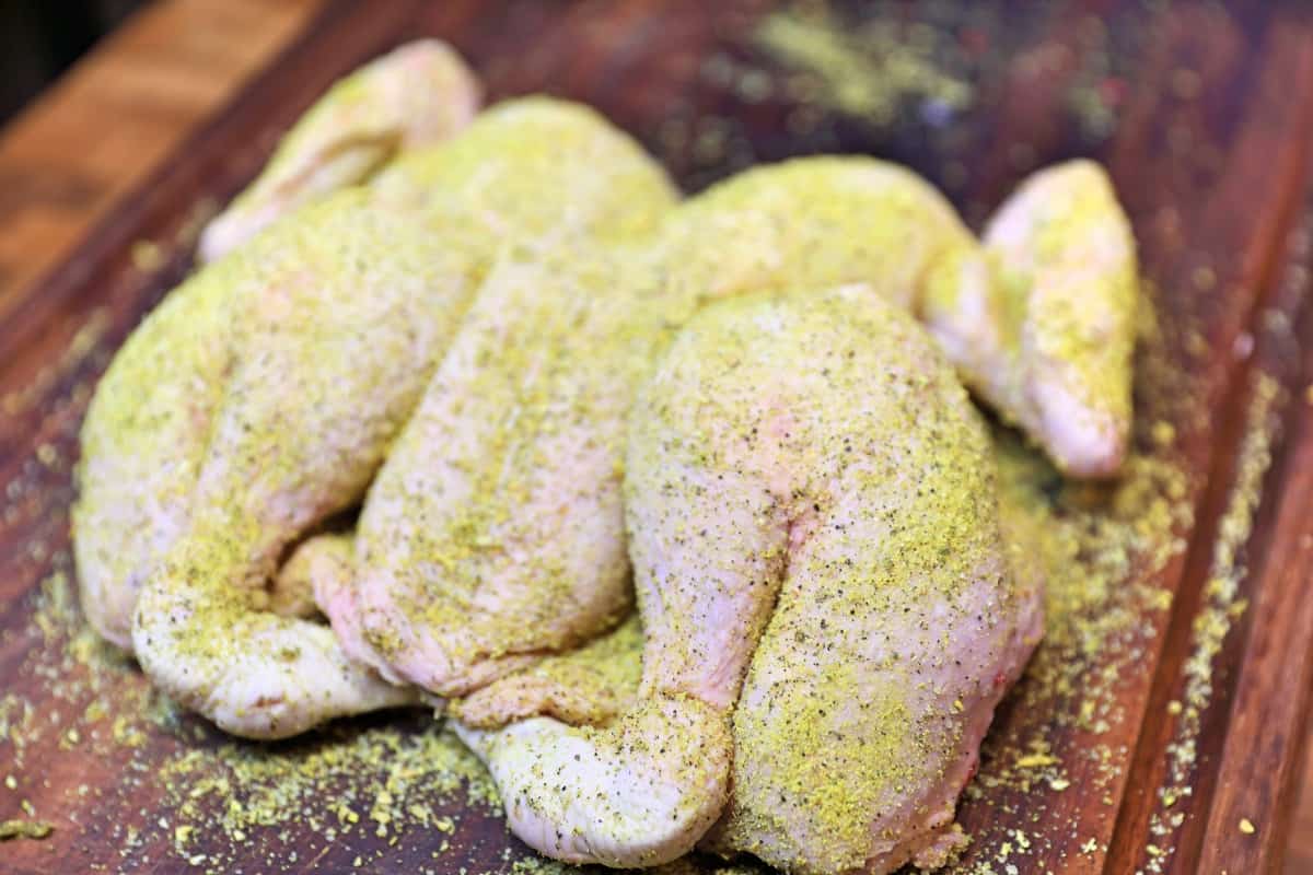 A dry rubbed, spatchcock chicken on a cutting board
