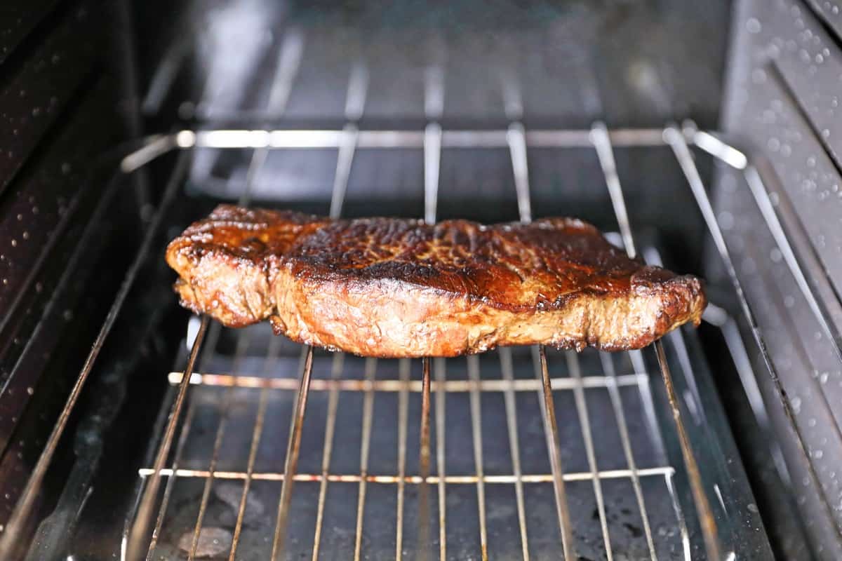 A steak in an oven, being reheated on a wire r.