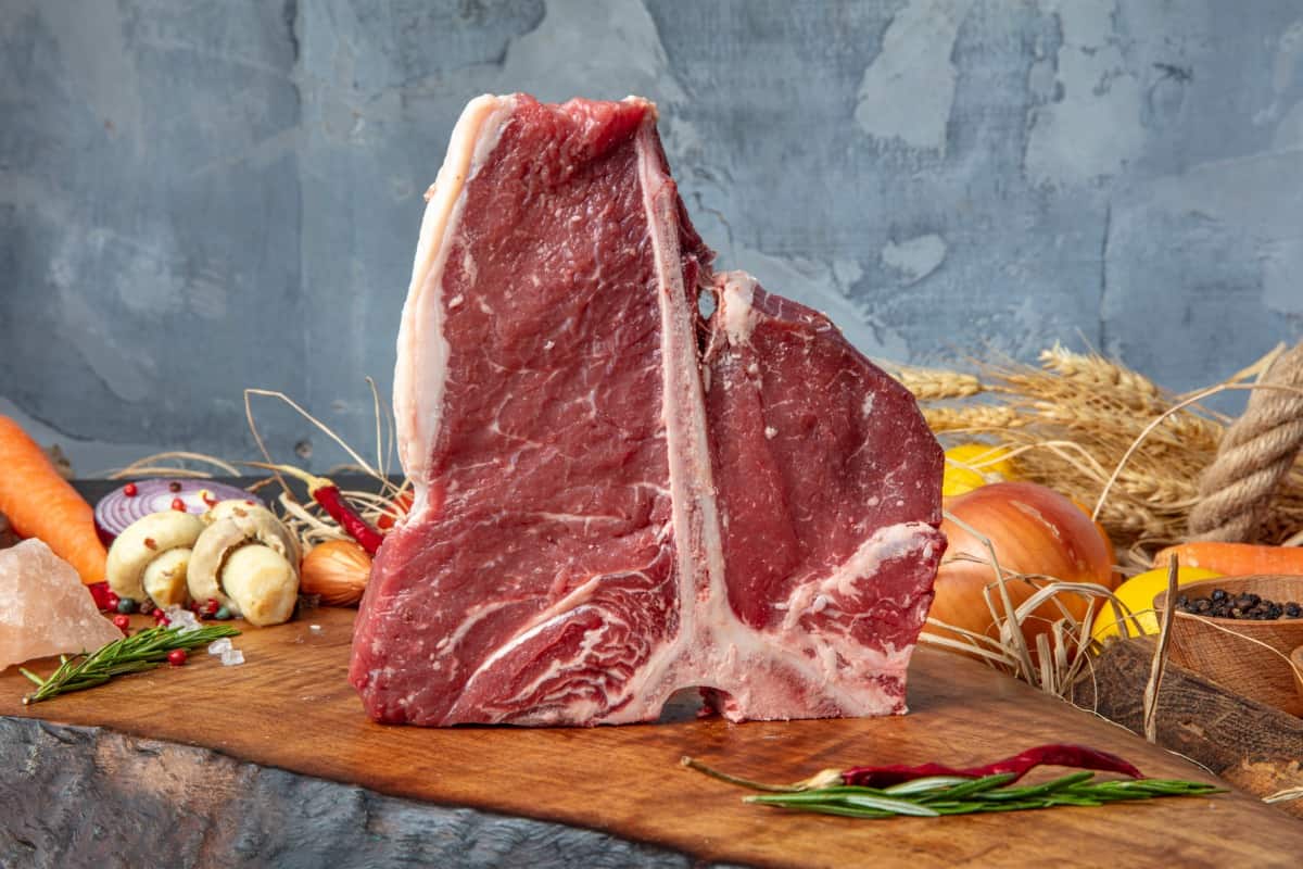 A porterhouse steak stood up on it's bone on a cutting board
