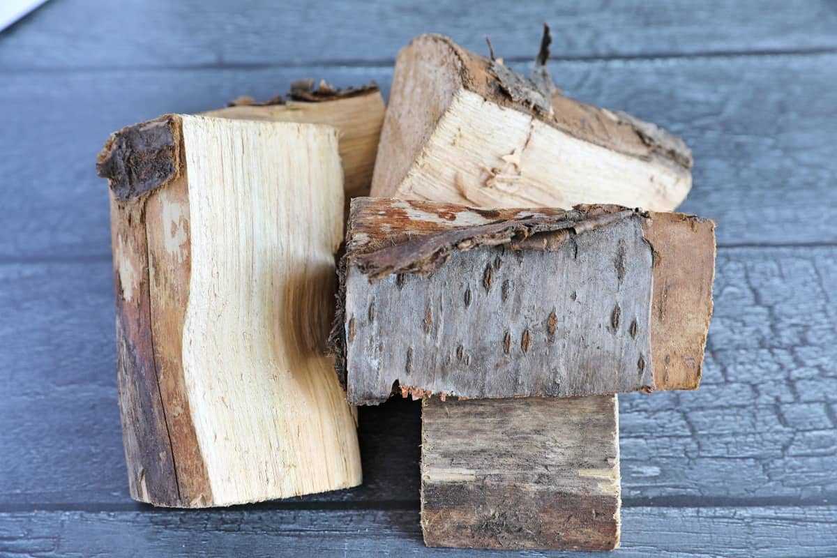 A small pile of cherry wood chunks on a dark table.