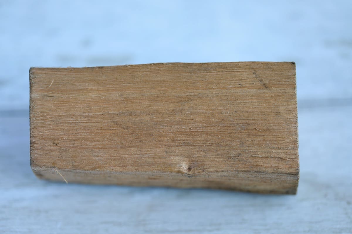 A piece of darker alder wood, showing its grain.