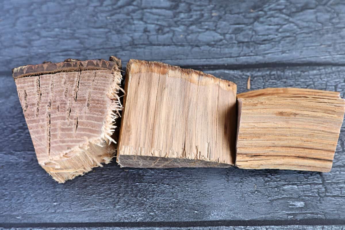 Three chunks of hickory wood on a dark wooden table.