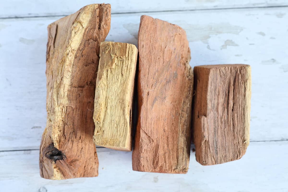 Four chunks of mesquite on a white wooden table.
