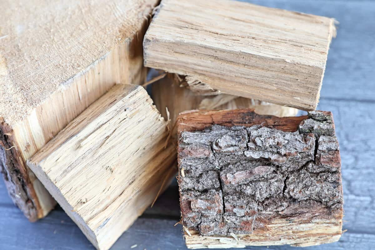 A close up of some oak wood chunks on a dark table.