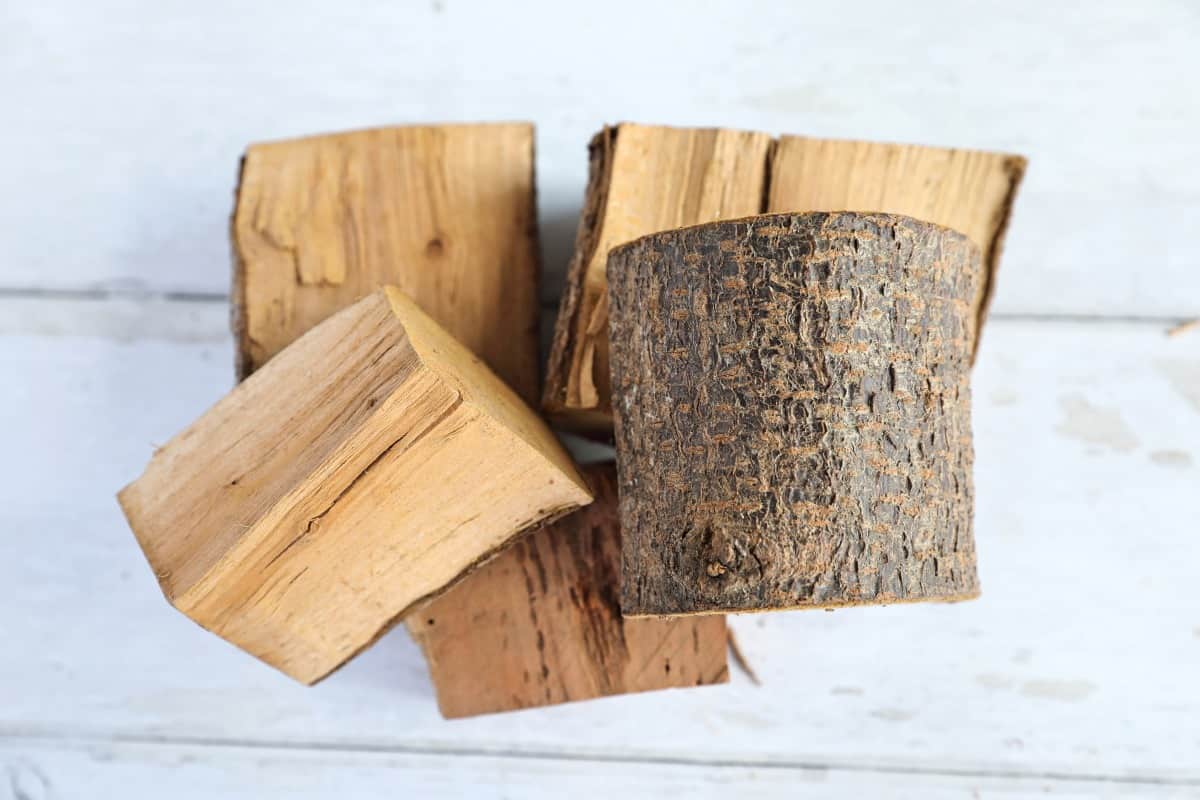 A small pile of plum wood chunks on a white table.