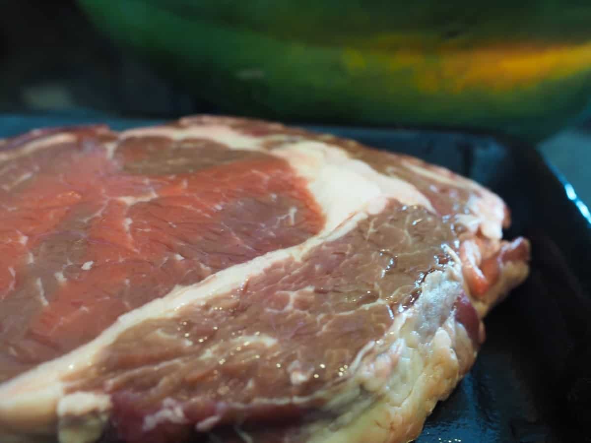 Close up of the corner of a discolored, highly likely gone bad steak