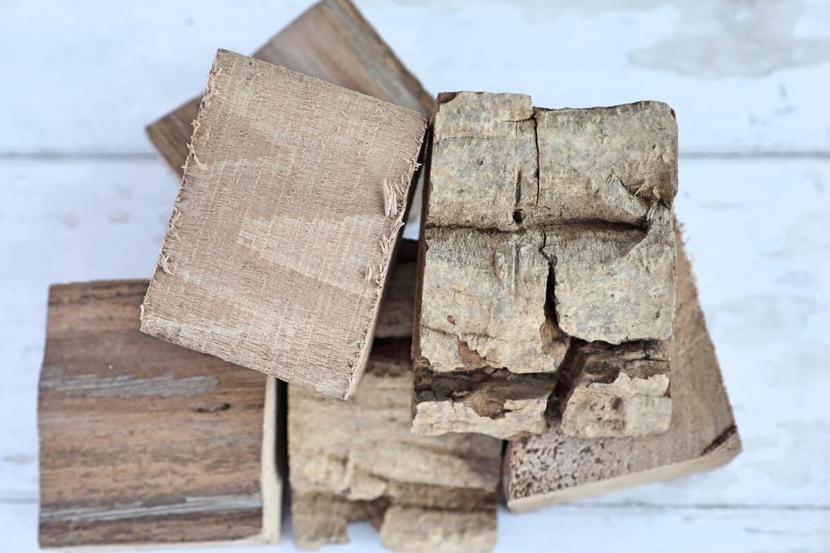 A small pile of walnut smoking wood chunks on a white table.