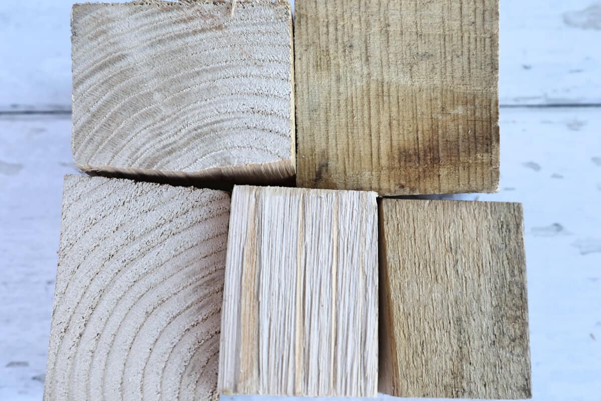 Five chunks of chestnut smoking wood on a white wooden table.