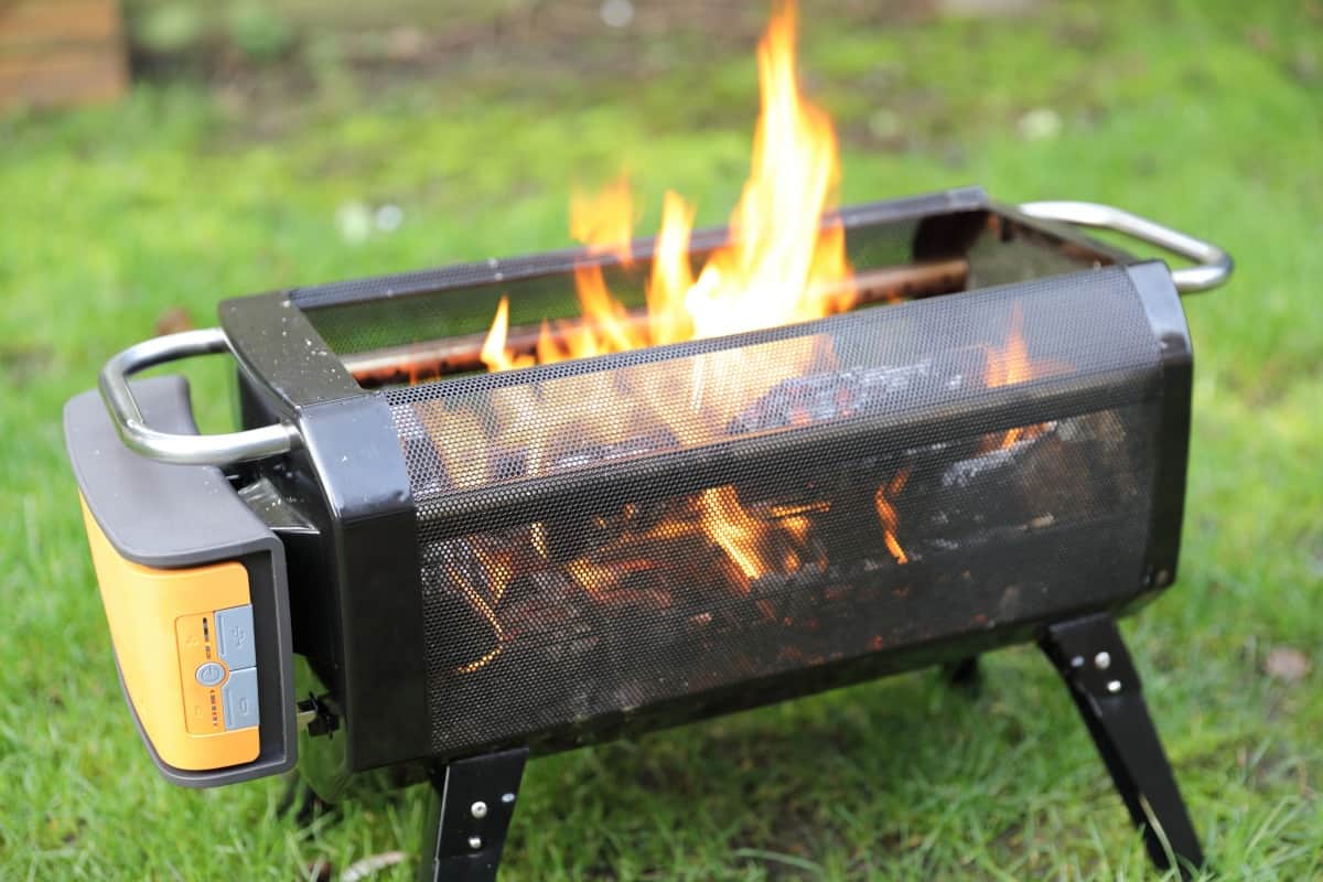 The BioLite firepit+ with a few burning logs ins.