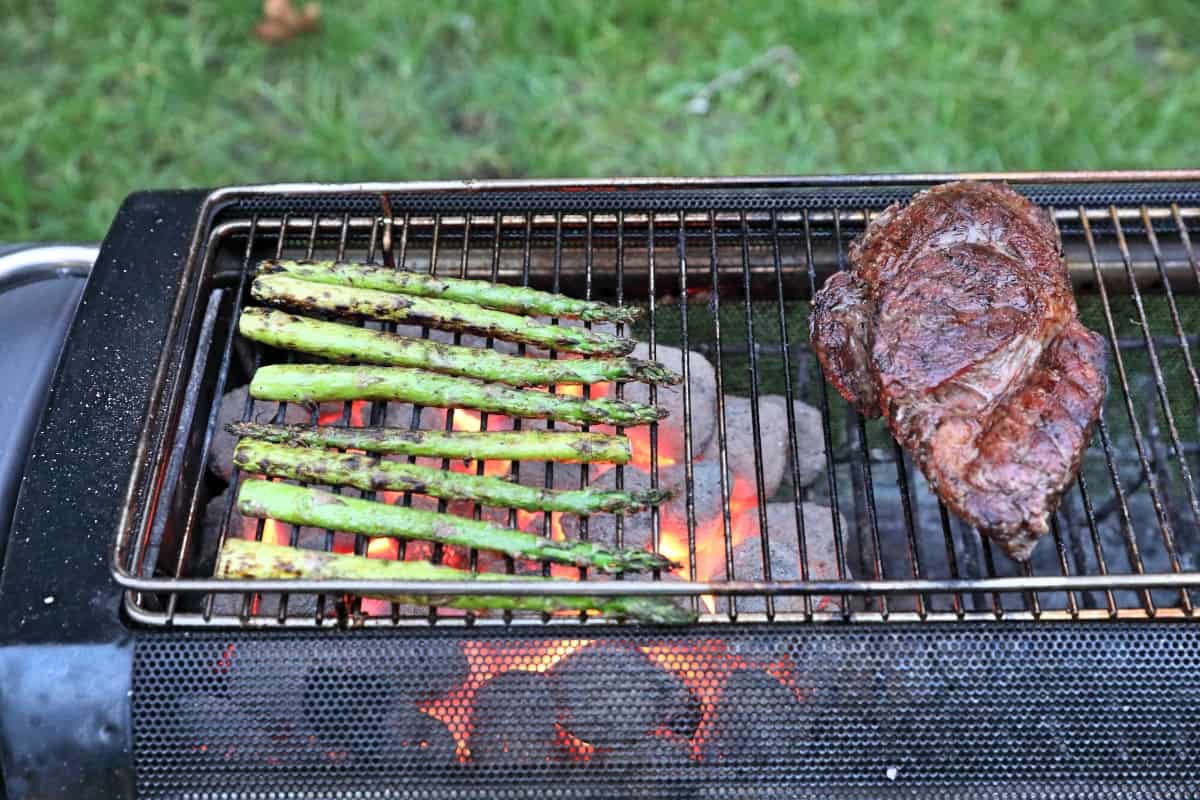 Grilling asparagus - with a steak being kept warm off the flames - on a BioLite firepit+