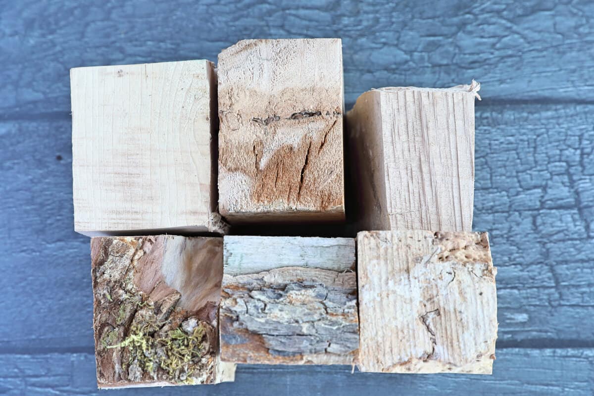 Six chunks of maple wood smoking chunks on a wooden table.
