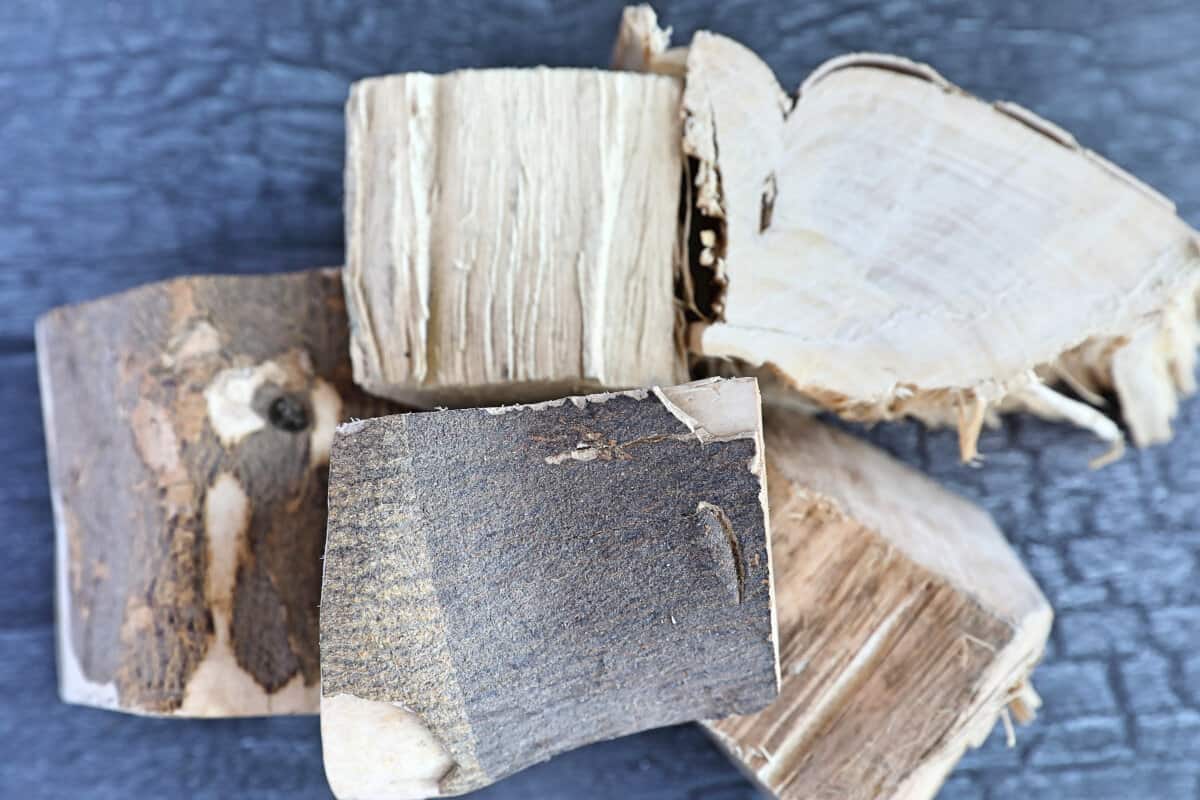 A small pile of orange wood chunks on a dark table.