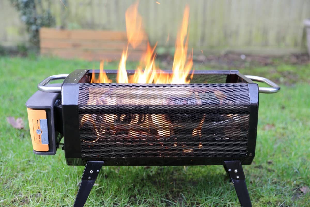 Side shot of the BioLite Firepit+ with a lit fore, showin how you can see through the x-ray mesh walls to see the fire inside